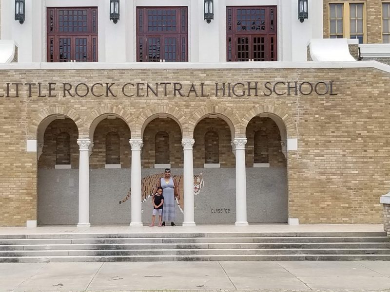 Dr. Vanessa Scott-Thompson stands with her child in front of the Little Rock Central High School