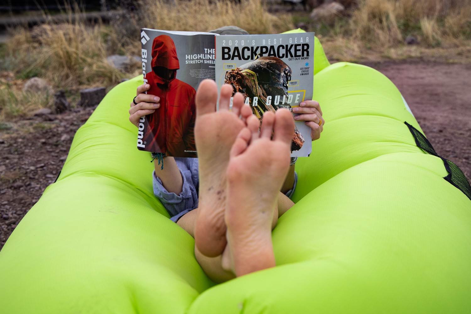 feet up relaxing on an inflatable while reading a magazine