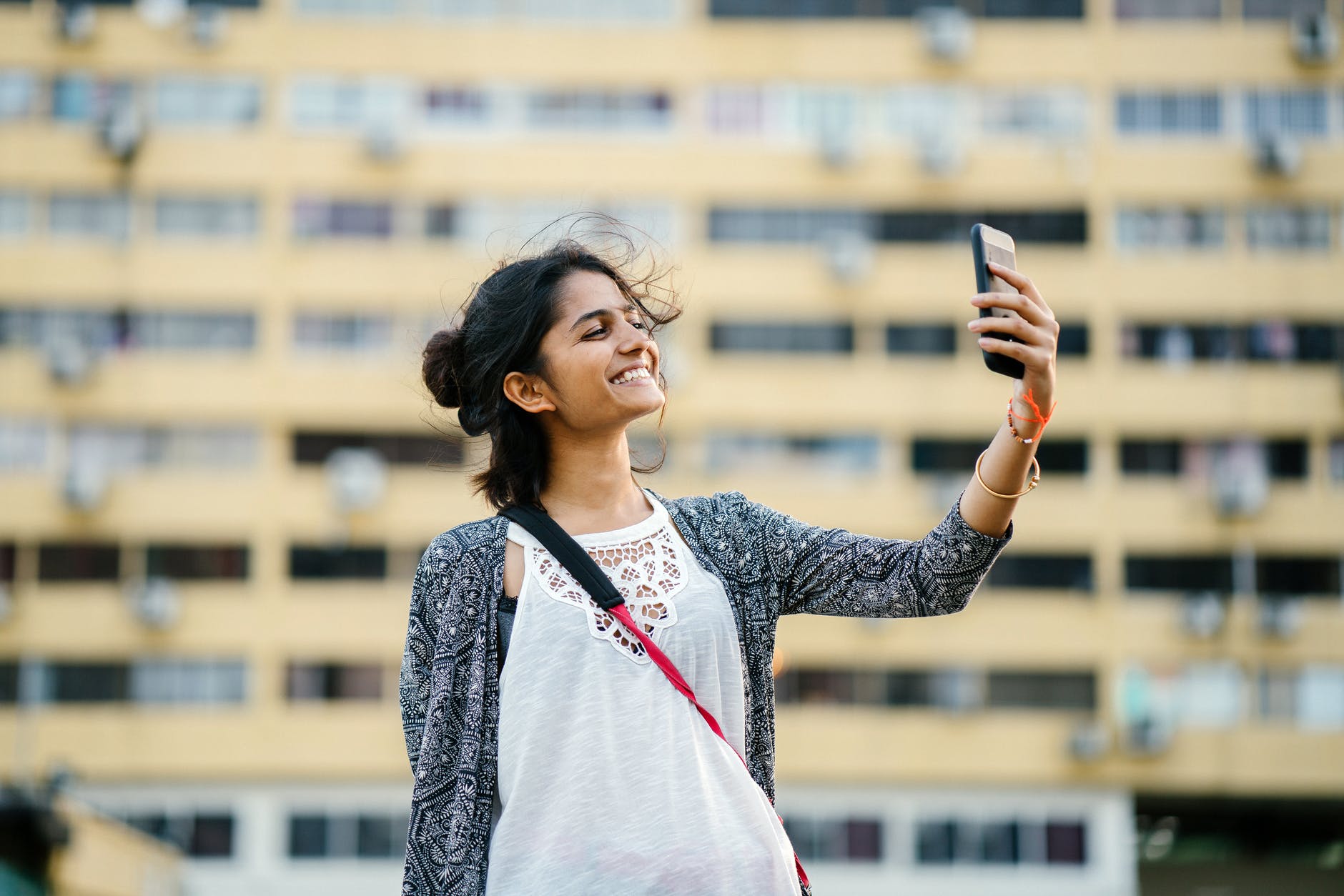 smiling woman holding black smartphone