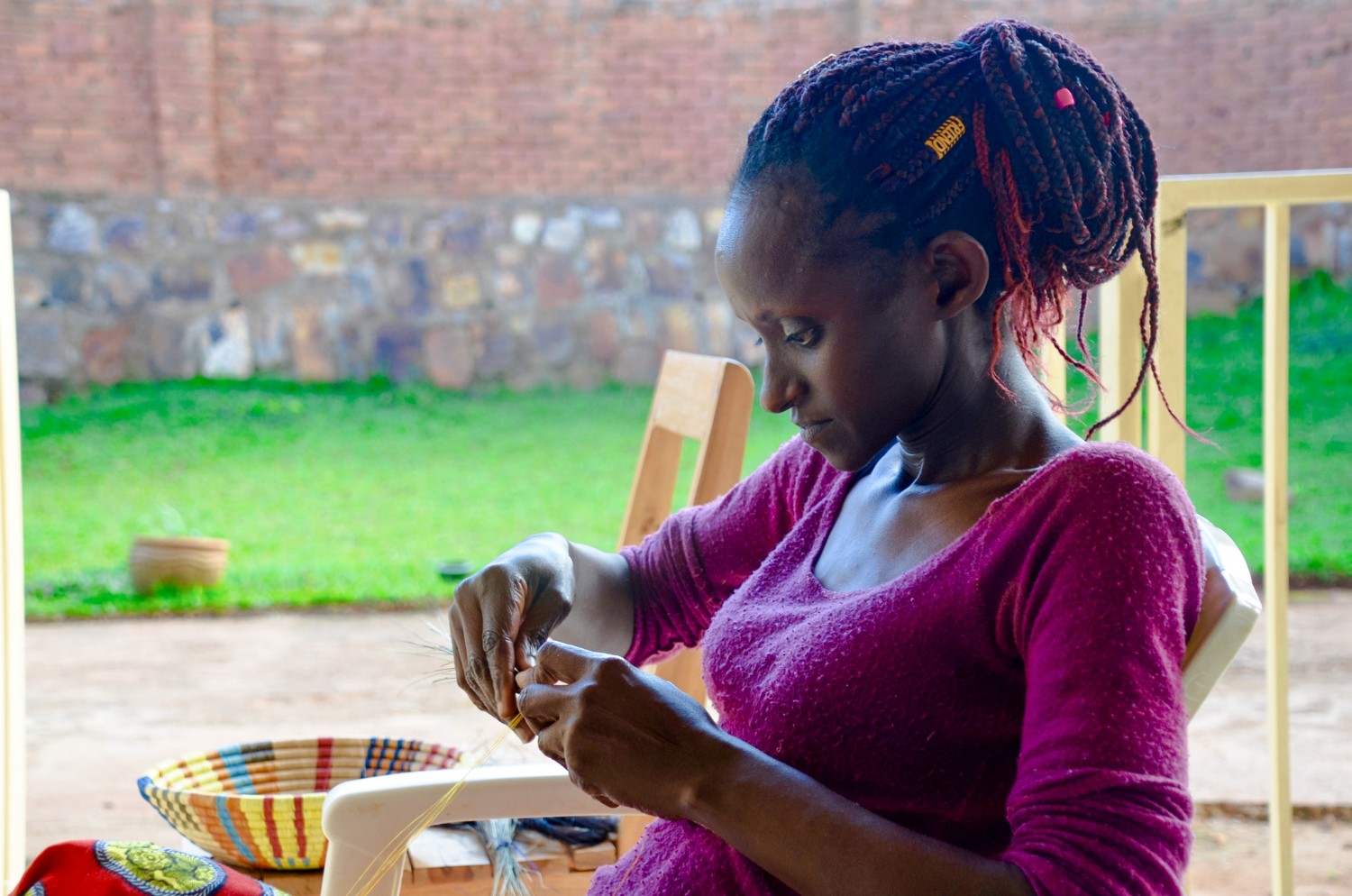 A Rwandese woman weaving a peace basket at Talking Through Art, a women's weaving cooperative