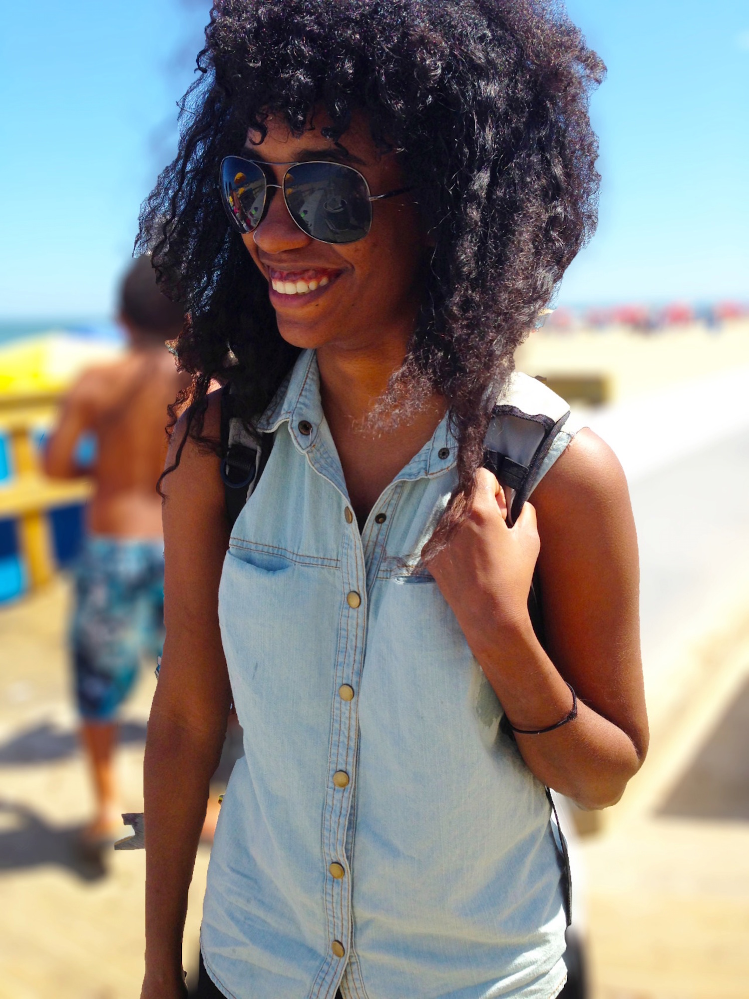 Solo travel for Black women - a smiling Black woman with a backpack on