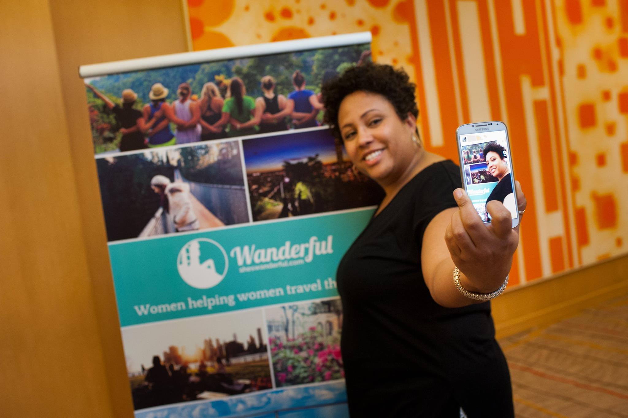 Travel for Black women -- a guide from Wanderful, the creators of the Women in Travel Summit [image of a Black woman taking a selfie at a WITS conference]