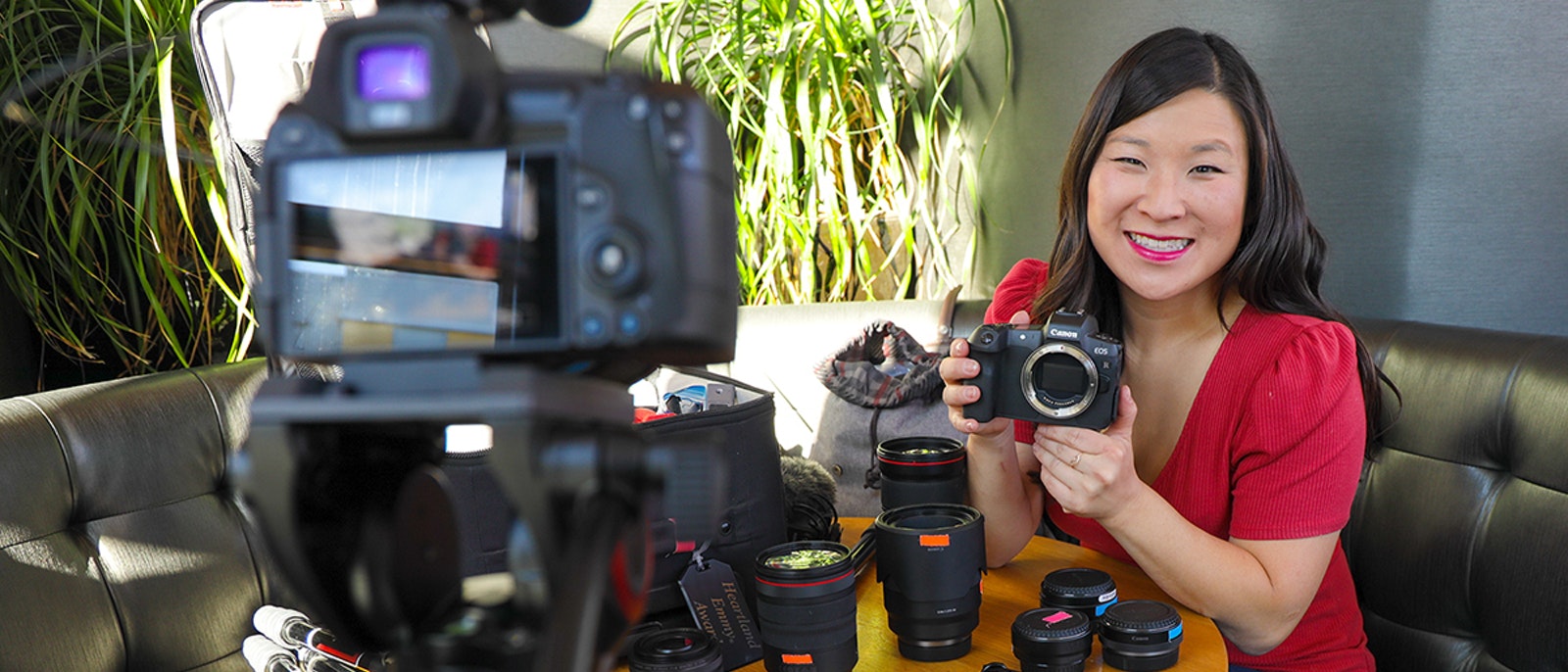 Juliana Broste holding a camera in front of other camera gear | Wanderful membership event