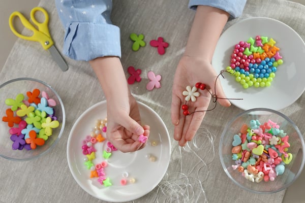 17 Beading Crafts for Kids | Beading is a great way to improve fine motor skills in kids, and can also improve dexterity and strengthen hand muscles. Also? It's fun! You'll be amazed at what you can make with a pipe cleaner and a seat of perler beads, and there are tons of DIY beaded jewelry crafts you can do with kids of all ages. If you have wooden, plastic, or glass beads on hand, this collection of bead crafts and jewelry making ideas will not disappoint!