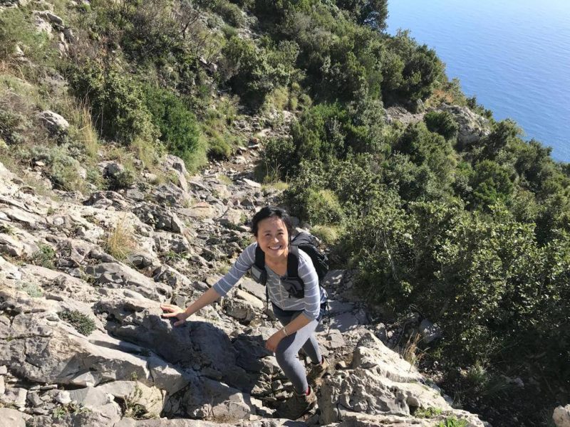 Grace Fujimoto, Acquisitions VP at Moon Travel Guides, smiling as she takes on a rocky, steep hike