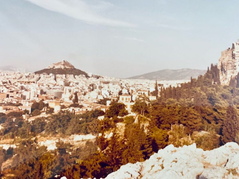 An old picture of Greece in the 80s. A view of a city and mountains. 